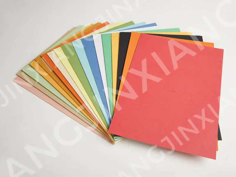 In what ways does the texture of leather grain paper covers enhance the tactile experience for users of leather-bound notebooks and planners?